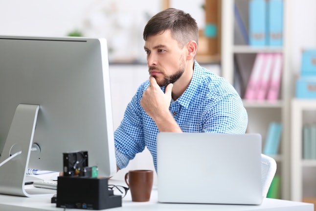 Handsome young programmer working in office